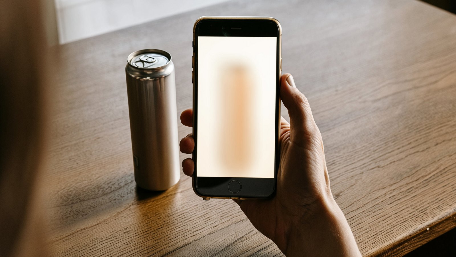 Hand holding a phone to film an unlabeled product on a plain surface, PELORA creator content for direct to consumer brands