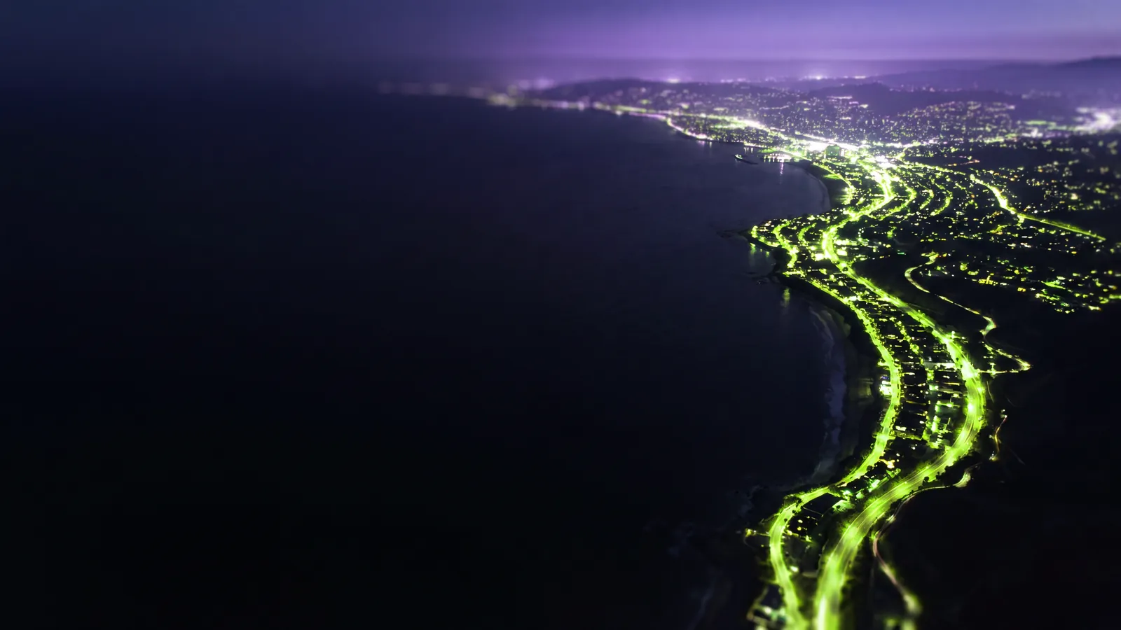 Concept render: a coastline at blue hour with green city lights